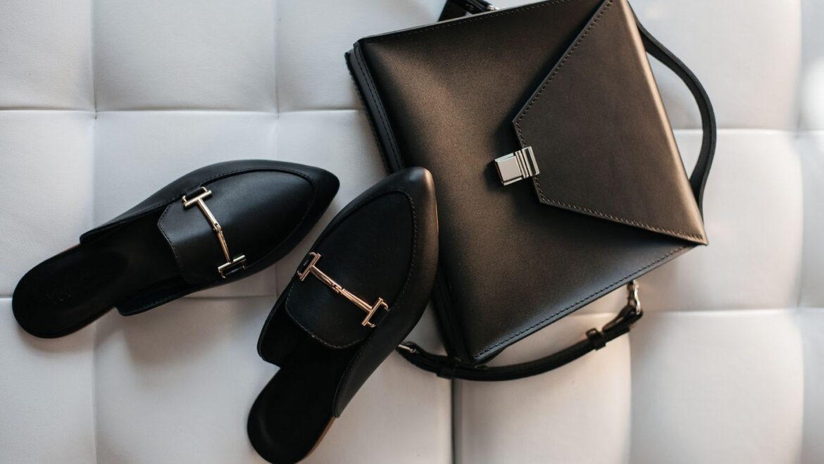 Zapatos negros y cartera de cuero sobre fondo claro